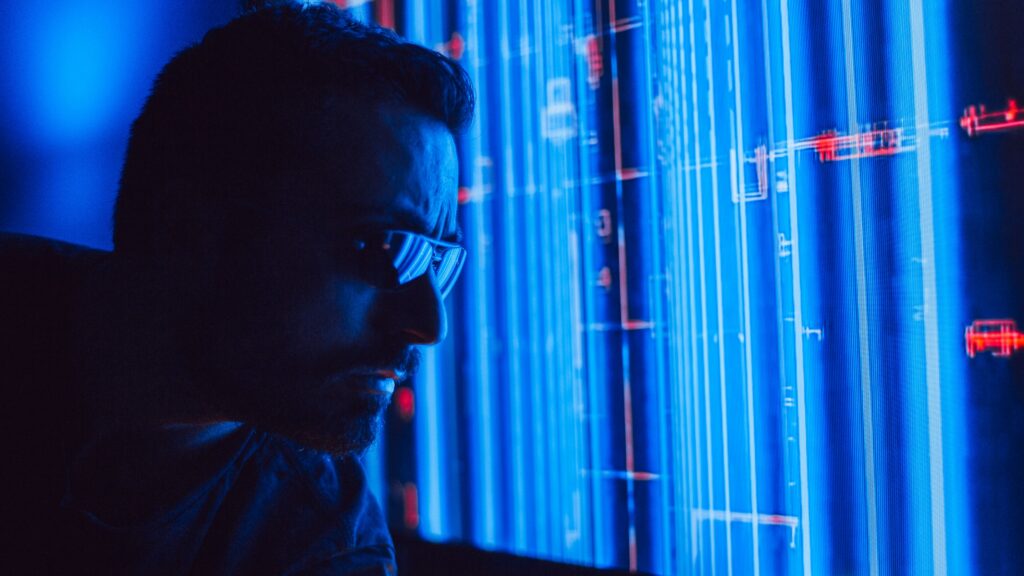 Analyst studying a holographic data screen, representing AI-assisted threat analysis
